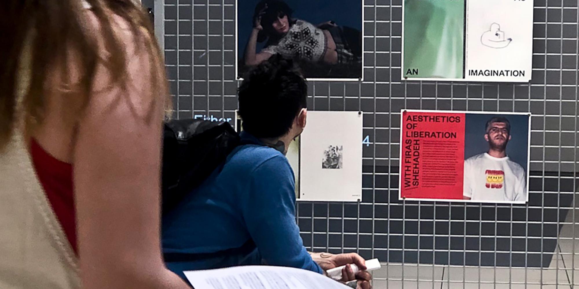Zwei Menschen sehen auf eine Ausstellungswand